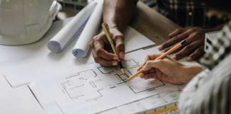 Vacancy: Chief Engineer at the Public Works Department Team construction engineers working at construction site with blueprint on table