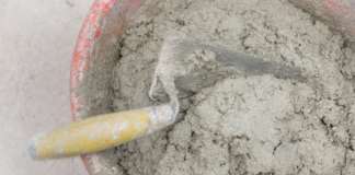 PWD’s Activity for Monday, June 16, 2025 Bucket with cement or plaster with two trowels inside, both covered in cement residue, top view